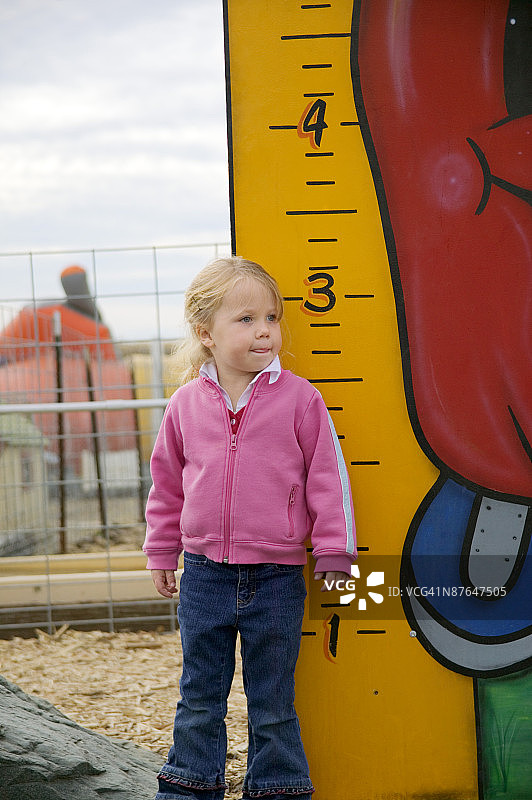 女孩站在室外体重秤旁图片素材