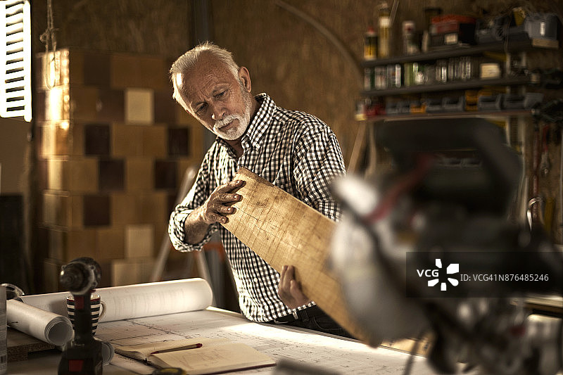 正在挑选合适木材的中年木匠图片素材