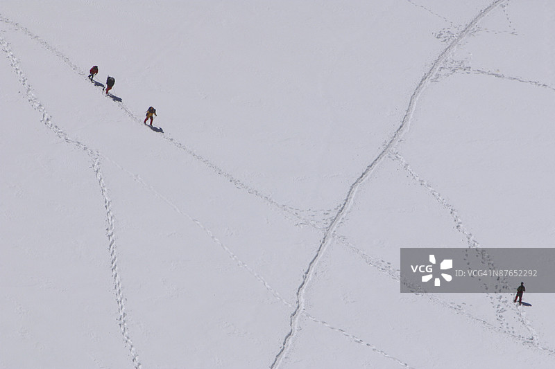 阿尔卑斯山脉的登山者在雪中徒步旅行图片素材