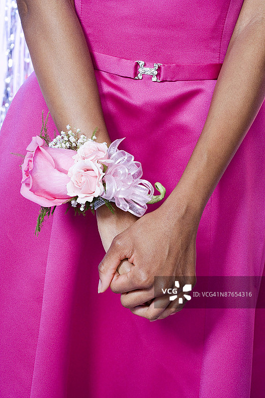 女孩手腕上戴着毕业舞会腕花的特写图片素材