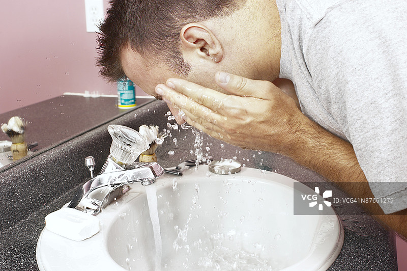 男子在洗手池洗脸图片素材