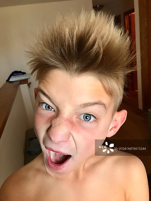 男孩蓬乱着头发，做着凶狠的表情图片素材