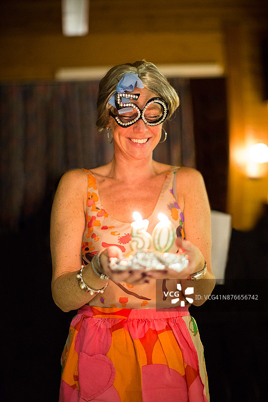 在挪威，一位女人在冬日里点燃蜡烛庆祝她的50岁生日图片素材