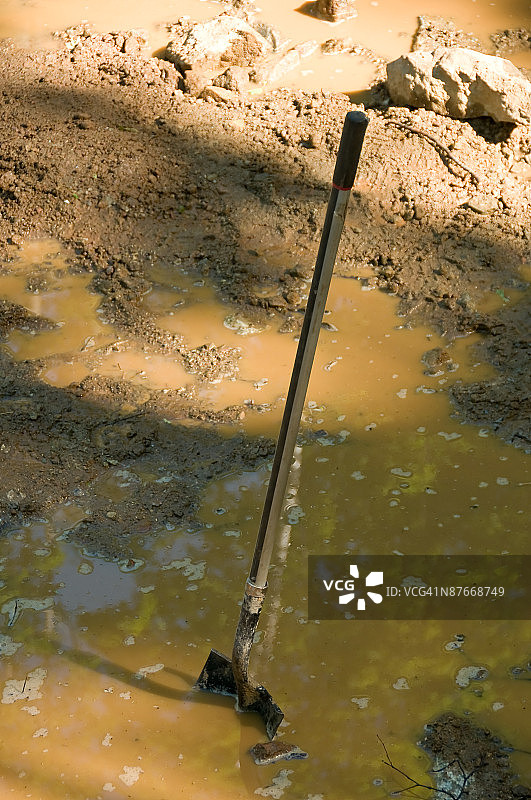 建筑工地里陷在泥里的铲子图片素材