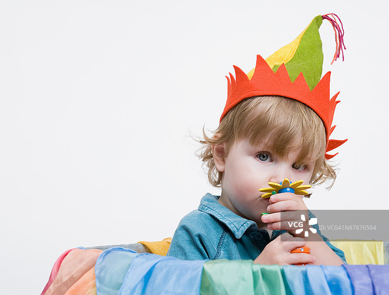 幼儿男孩嗅着假花的影棚照图片素材