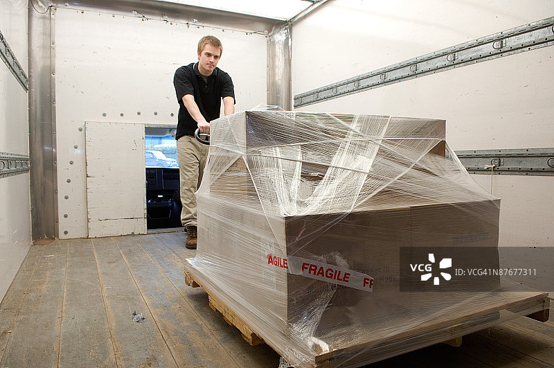 男人将货物装载到送货卡车上图片素材