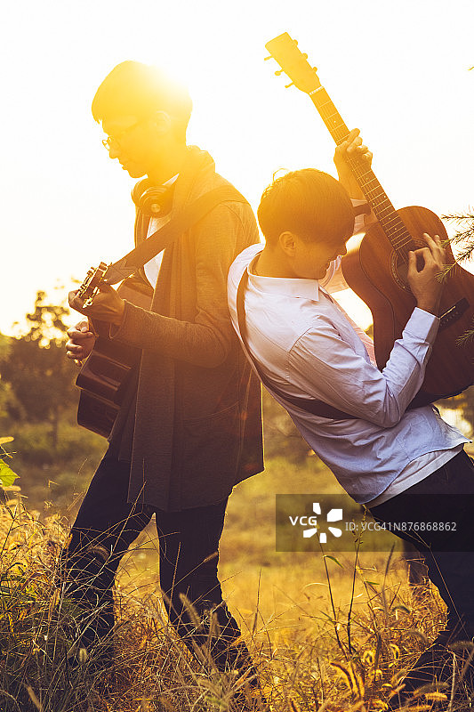 两名男子在公园草坪上弹吉他图片素材