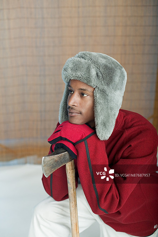 戴着冬季帽子拿着斧头的男人图片素材