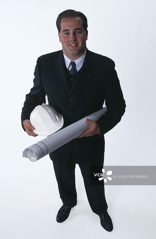 戴着安全帽的建筑师与蓝图图片素材