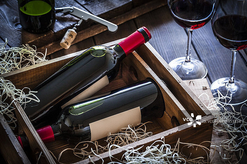 装在木箱里的葡萄酒瓶，置于乡村木桌上图片素材