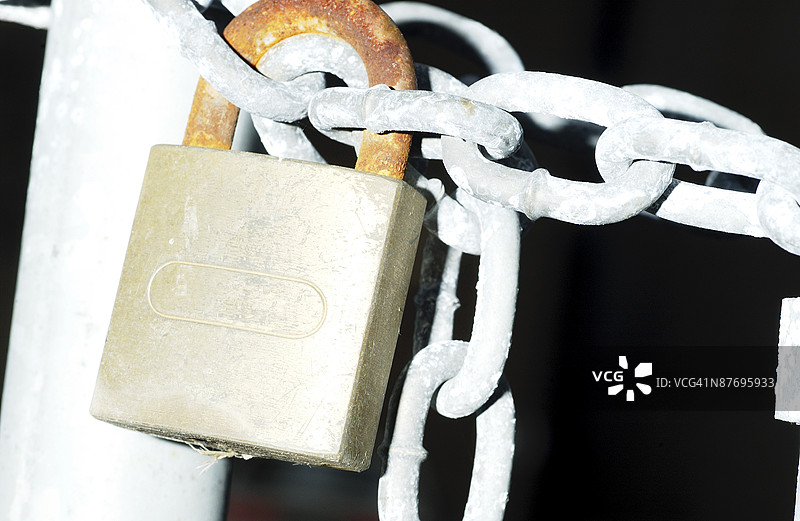 夜间大门上的锁和链条特写图片素材