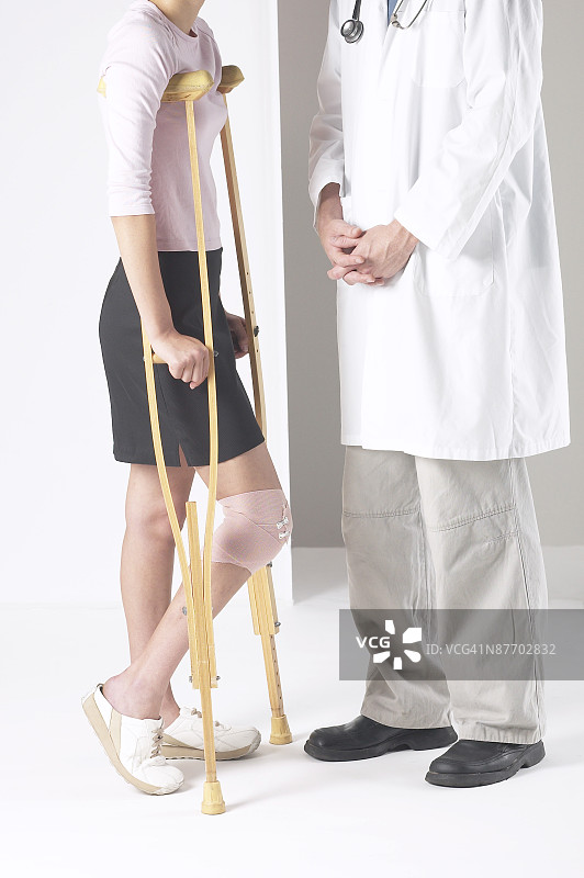拄着拐杖的女人和医生在一起图片素材