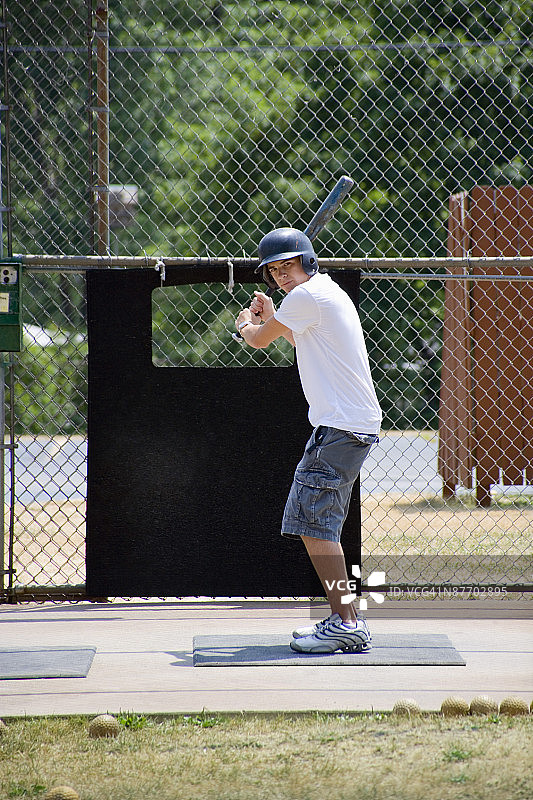在棒球击球笼里的青少年男孩图片素材