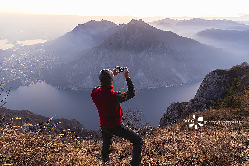 徒步者在湖泊之上的山顶上图片素材