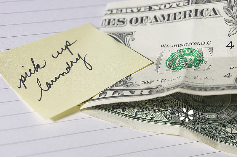 一美元纸币旁的洗衣便条图片素材