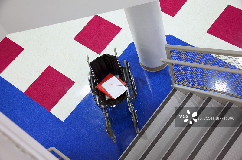 楼梯底部的轮椅与文件夹图片素材