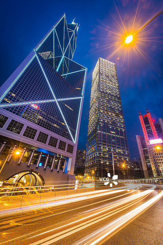 香港中环的摩天大楼在夜间被照亮，车流穿梭图片素材