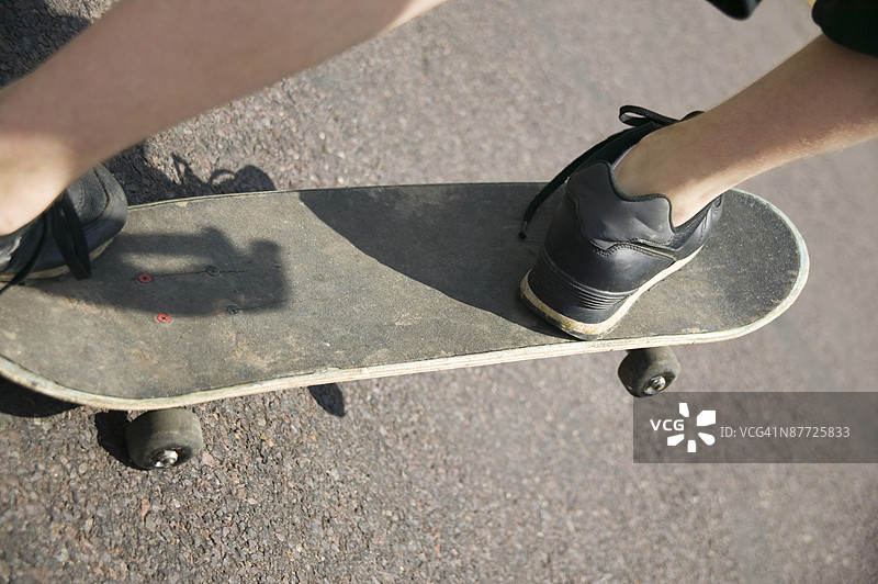 男孩的脚踩在滑板上图片素材