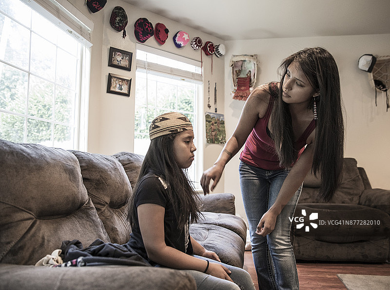 美国原住民母亲和女儿在家试戴祖母的尤洛克编织帽图片素材