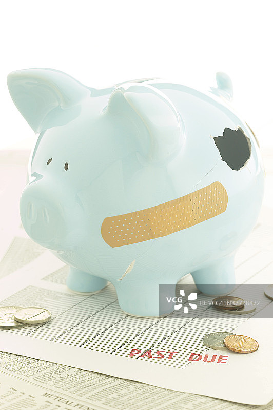 放在钞票上的缠着绷带的储蓄罐图片素材