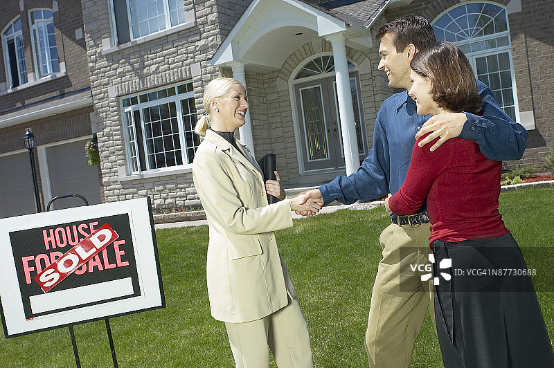 情侣与房地产经纪人握手图片素材