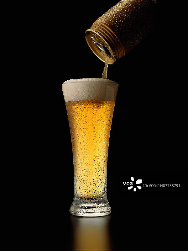啤酒倒入比尔森玻璃杯中图片素材