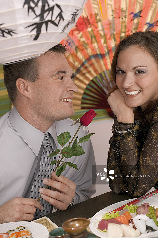 男人在寿司店向女人赠送玫瑰花图片素材