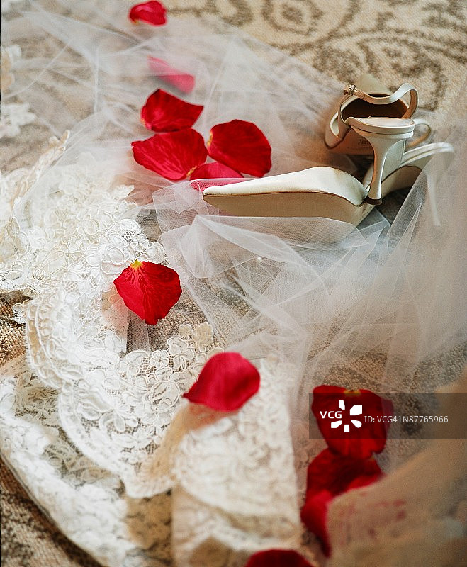 地毯上的婚纱、鞋子和玫瑰花瓣图片素材