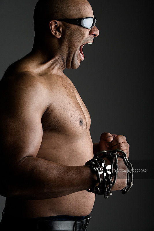 愤怒的健壮男人展示锁链图片素材