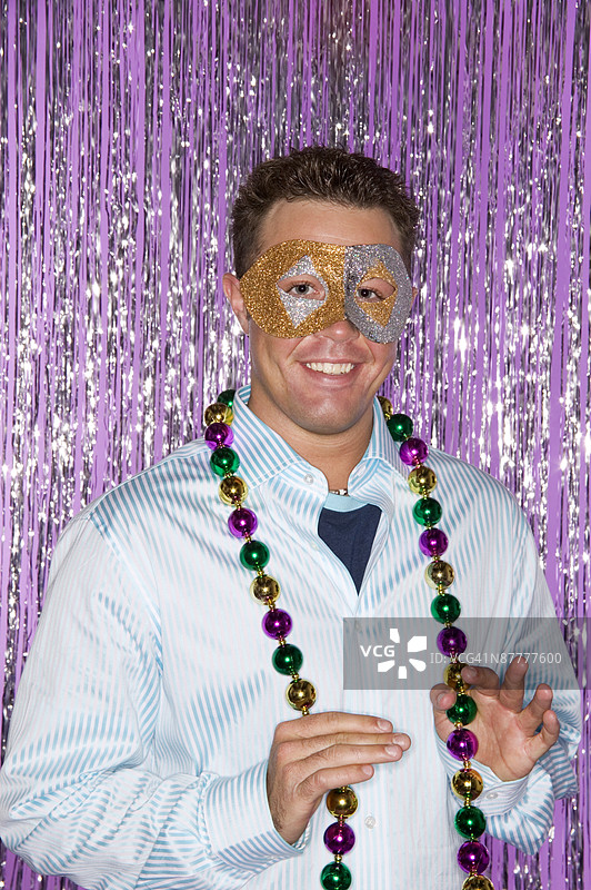 戴着狂欢节面具和珠子的男人图片素材