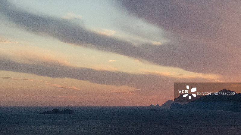 第勒尼安海上色彩斑斓的日落，背景是法拉廖尼岩柱图片素材