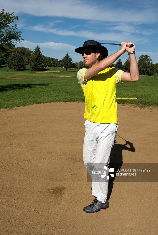 高尔夫球手在沙坑外击球图片素材