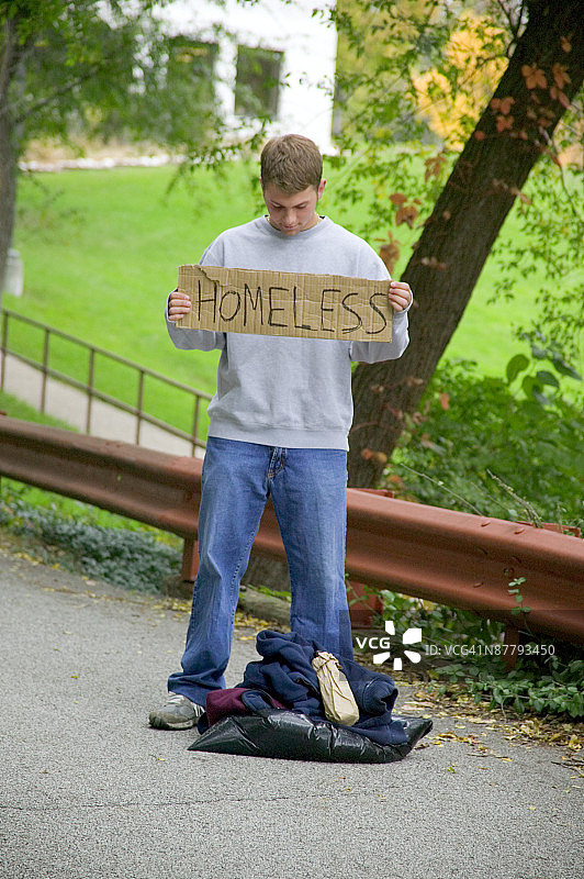 举着牌子的流浪少年图片素材