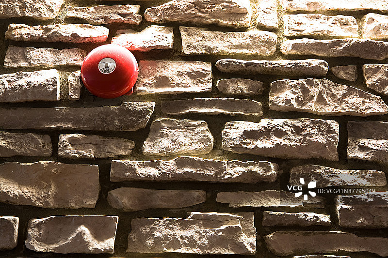 石墙上的红色警铃图片素材