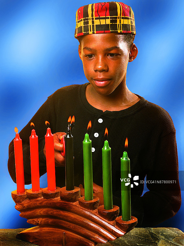 照片：男孩点燃宽扎节蜡烛（彩色高分辨率）图片素材