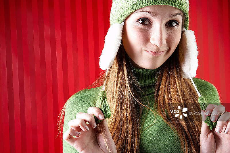 女人拧着针织羊毛帽上的流苏图片素材