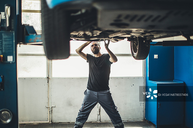汽车修理工在车间车辆下工作图片素材
