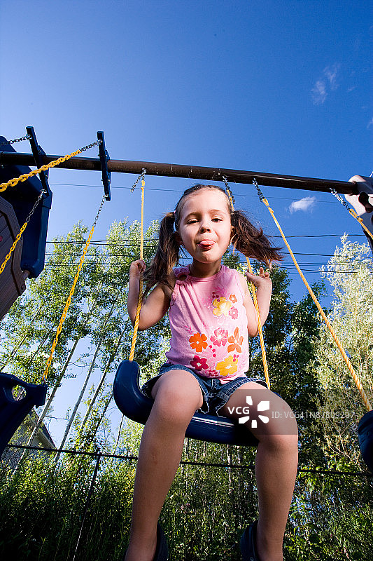 荡秋千吐舌头的女孩图片素材