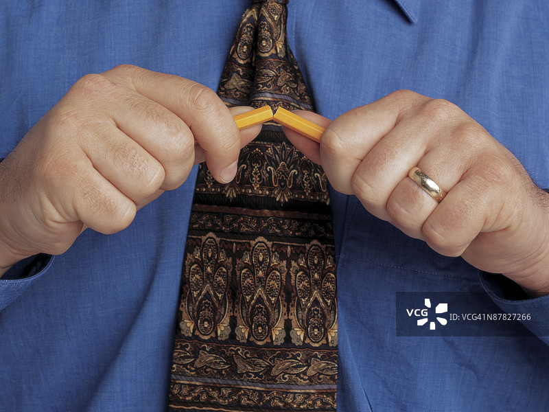 男人的手折断铅笔，特写图片素材