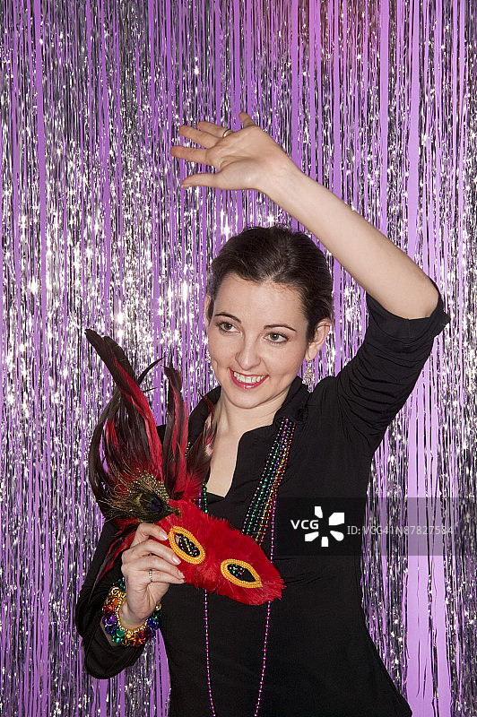 戴狂欢节面具和珠子的女人图片素材