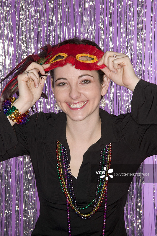 戴着马尔迪·格拉斯面具和珠子的女人图片素材