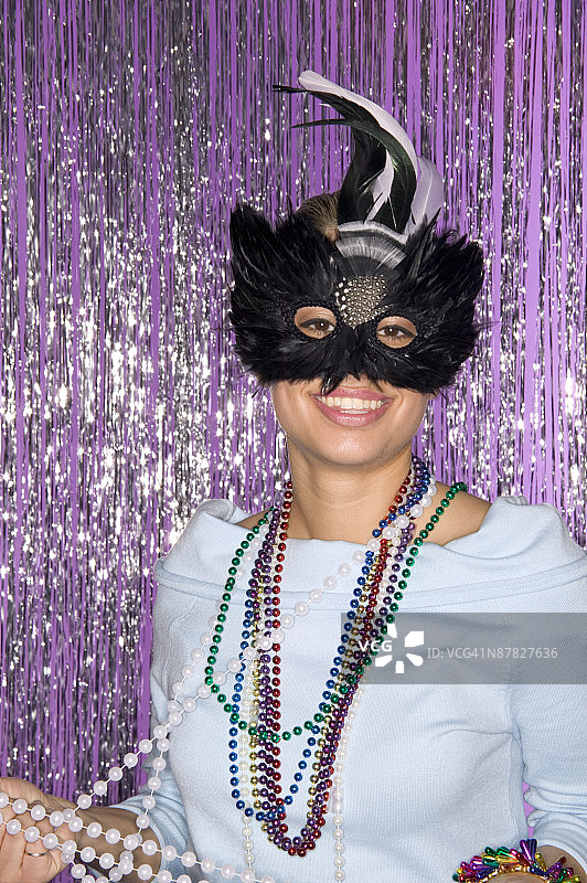 戴狂欢节面具和珠子的女人图片素材