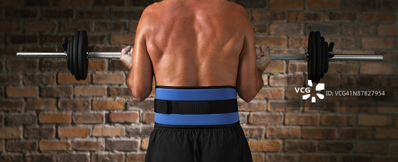 男性躯干，系着举重腰带正在举重图片素材
