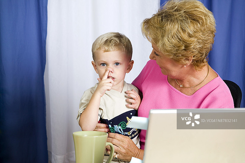 被女人抱着挖鼻孔的男孩图片素材