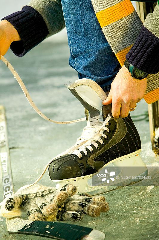 在冰鞋上系鞋带的手图片素材