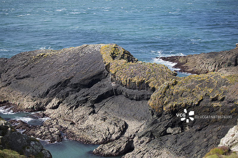 倾斜入海的岩石海岸线图片素材