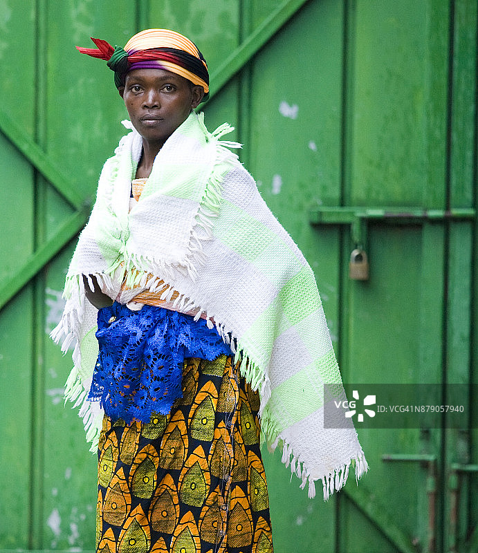 身穿传统服装站在绿色门前的女人肖像，布隆迪 Cibitoke Masango，非洲图片素材