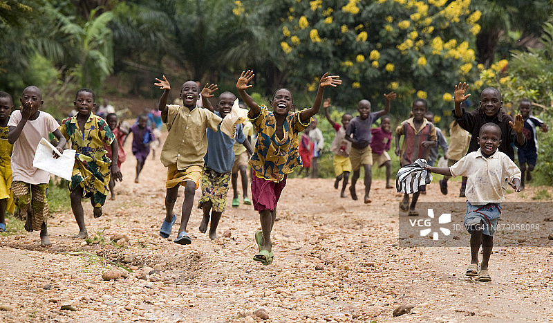 孩子们在非洲布隆迪锡比托克马桑戈的泥路上奔跑图片素材
