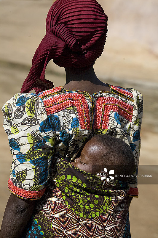 母亲用婴儿背带背着孩子的背影，布隆迪锡比托克马桑戈图片素材