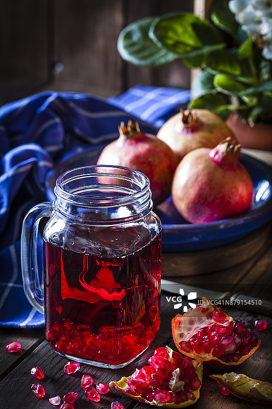 乡村木桌上的石榴汁杯图片素材